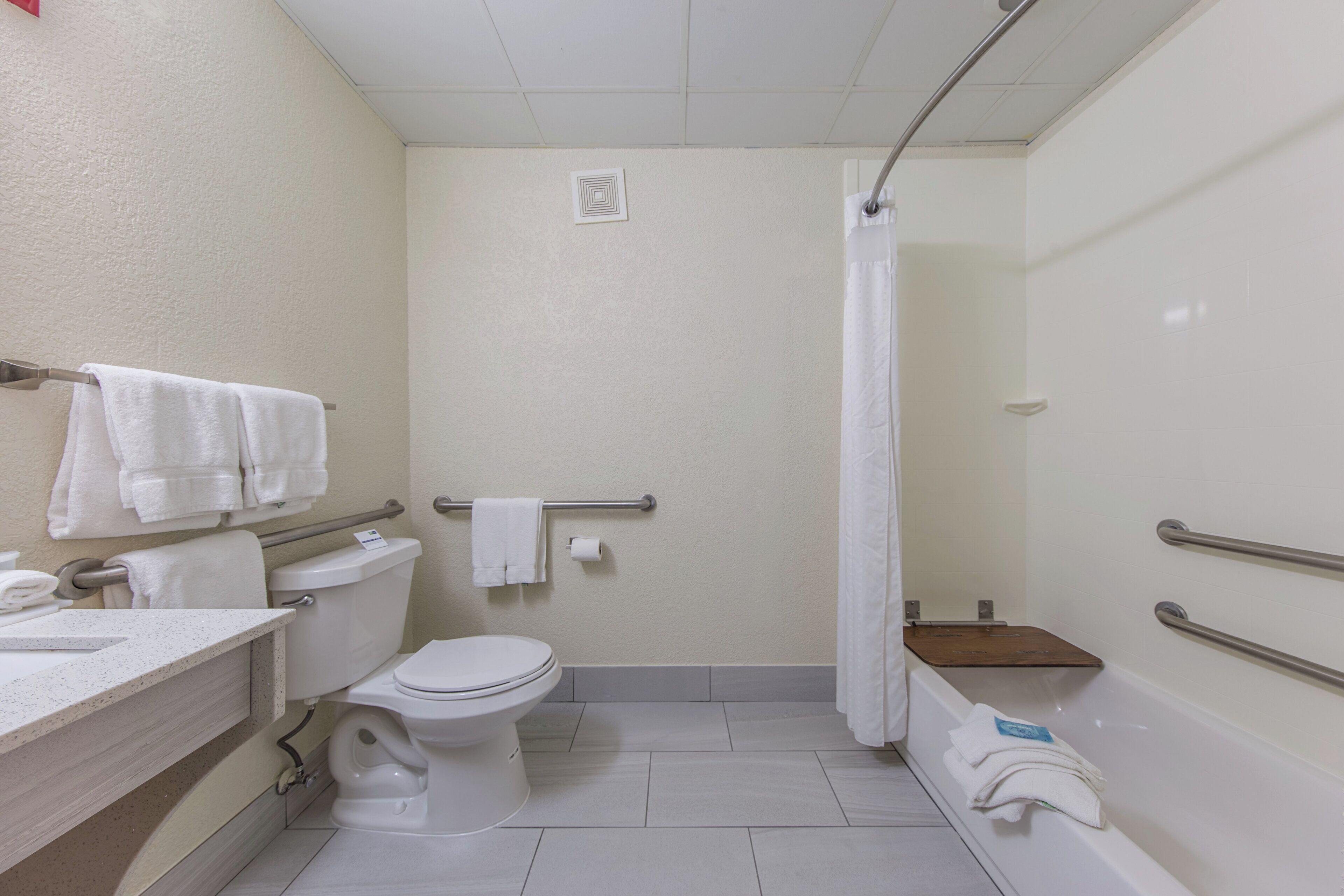 Un baño de hotel estándar con inodoro, lavabo y zona de ducha.