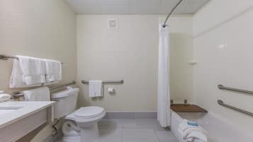 Un baño de hotel estándar con inodoro, lavabo y zona de ducha.