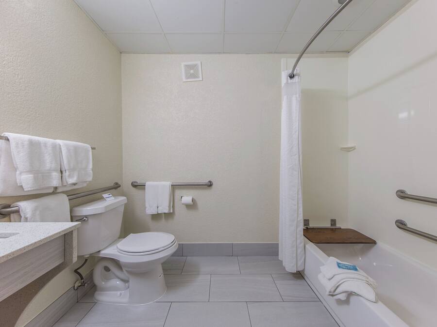 Un baño de hotel estándar con inodoro, lavabo y zona de ducha.