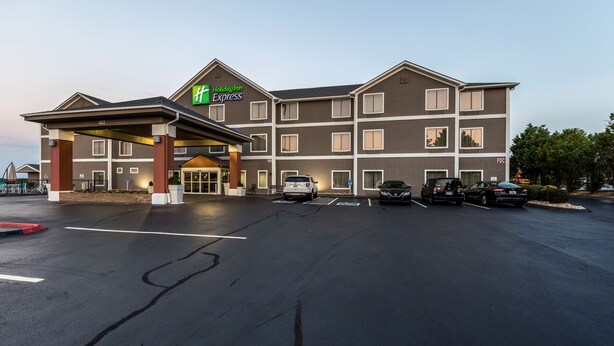 Un hôtel Holiday Inn Express doté d’une entrée abritée, de nombreux espaces de stationnement et offrant une vue sur un ciel dégagé.