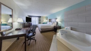 Une chambre d’hôtel avec un lit, un bureau, une chaise et une grande baignoire.