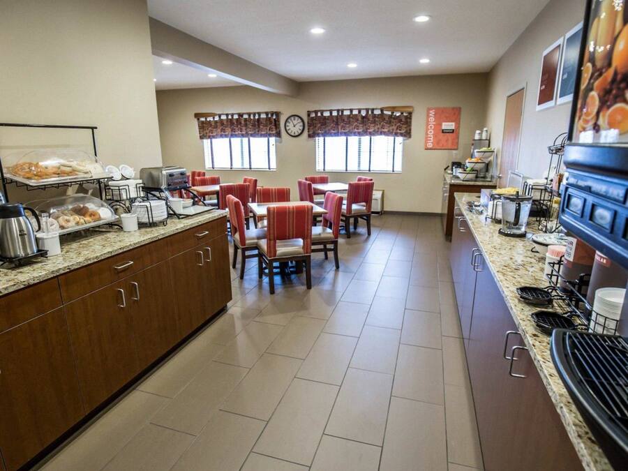 Een restaurantruimte in een hotel met een buffet, zitplaatsen en keukenapparatuur.