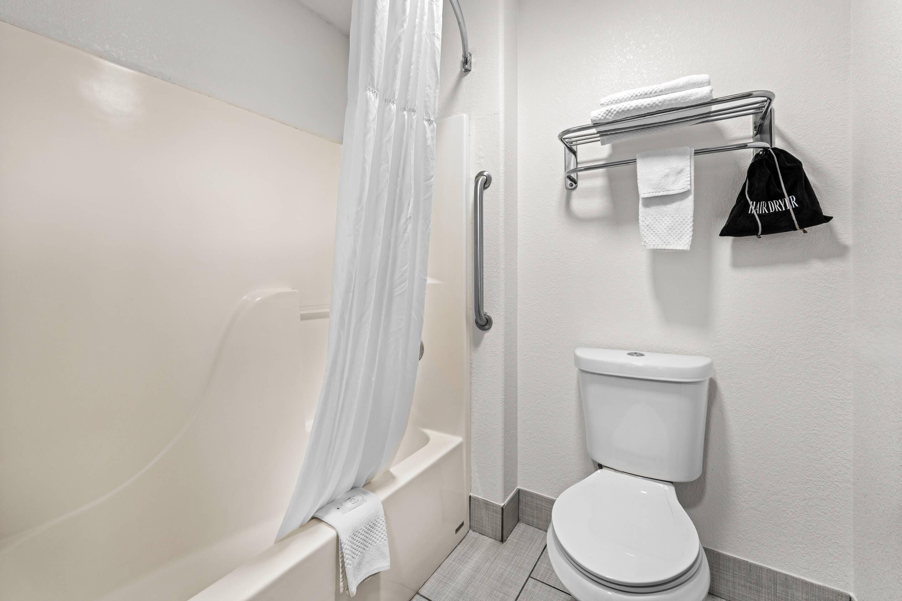 Ein Badezimmer mit Badewanne, Toilette und Handtuchhalter.