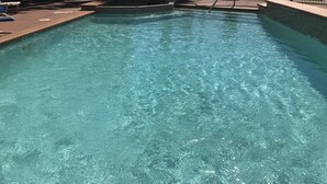 A clear swimming pool with a tiled edge and a metal ladder. - Quality Suites Houston NW Cy-Fair (Houston)