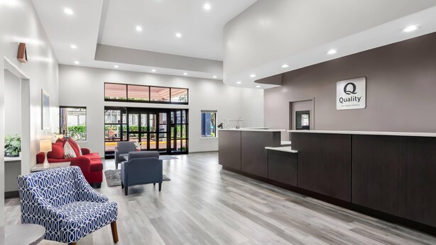 A modern hotel lobby with a reception desk, seating area, and large windows. - Quality Suites Houston NW Cy-Fair (Houston)