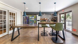 A modern interior with a wooden table, green chairs, and pendant lights. - Extended Stay America Premier Suites - Miami - Airport - Miami Springs (Miami Springs)