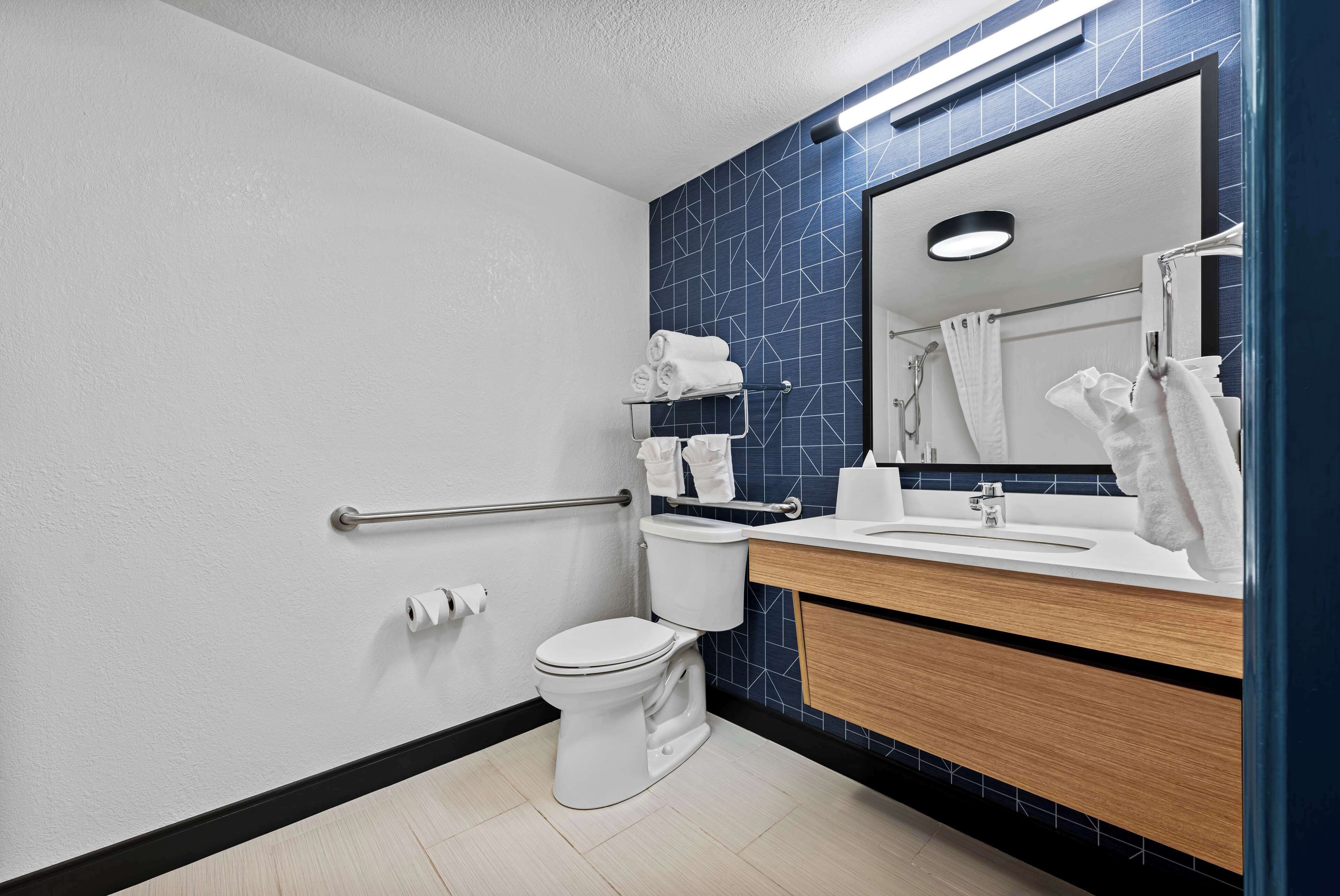 A modern bathroom with a toilet, sink, and towel rack.