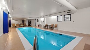 A swimming pool with a clear blue water, surrounded by lounge chairs and a tiled floor. - Days Inn by Wyndham Thornton (Thornton)