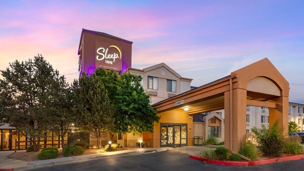 A Sleep Inn hotel with a large sign, a covered entrance, and a well-lit parking area. - Sleep Inn Denver Tech Center (Greenwood Village)