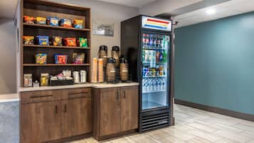 Un bar proposant une variété de chips et d’en-cas, une machine à café et un réfrigérateur rempli de boissons.