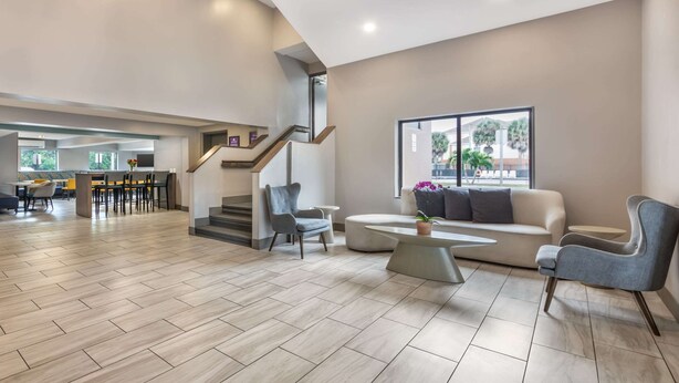 Un vaste espace de vie au design moderne, comprenant un escalier, un canapé et une table basse.
