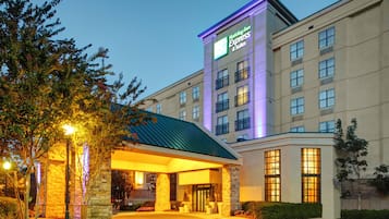 A Holiday Inn Express hotel with a modern design, featuring a prominent entrance and a well-lit facade.