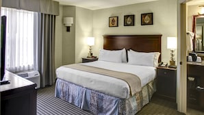 A hotel room with a large bed, two bedside tables with lamps, a desk, and a wardrobe. - Holiday Inn Express & Suites Atlanta Buckhead by IHG (Atlanta)