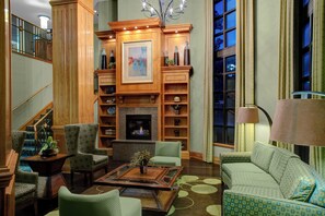 A spacious living room with a fireplace, comfortable seating, and a staircase leading to an upper level. - Holiday Inn Express & Suites Atlanta Buckhead by IHG (Atlanta)