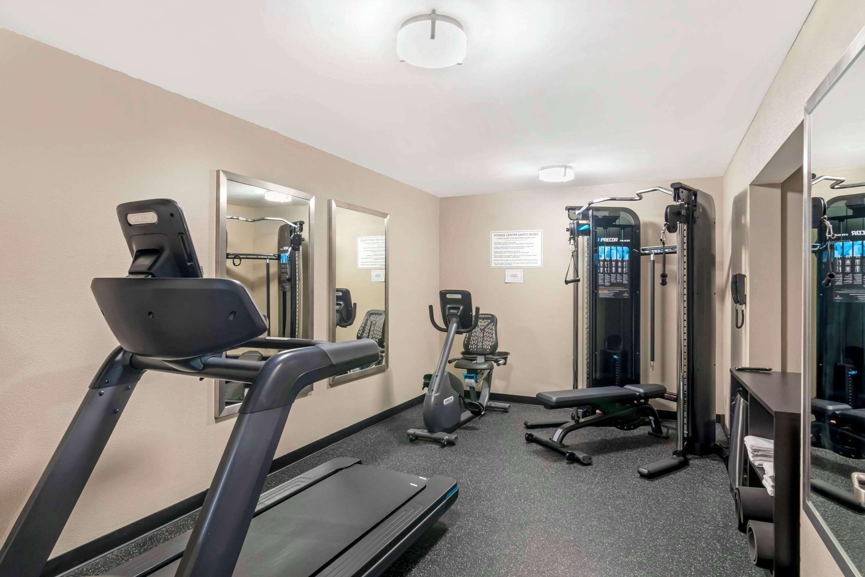 A gym with treadmills, an elliptical, a bench, and weight machines.