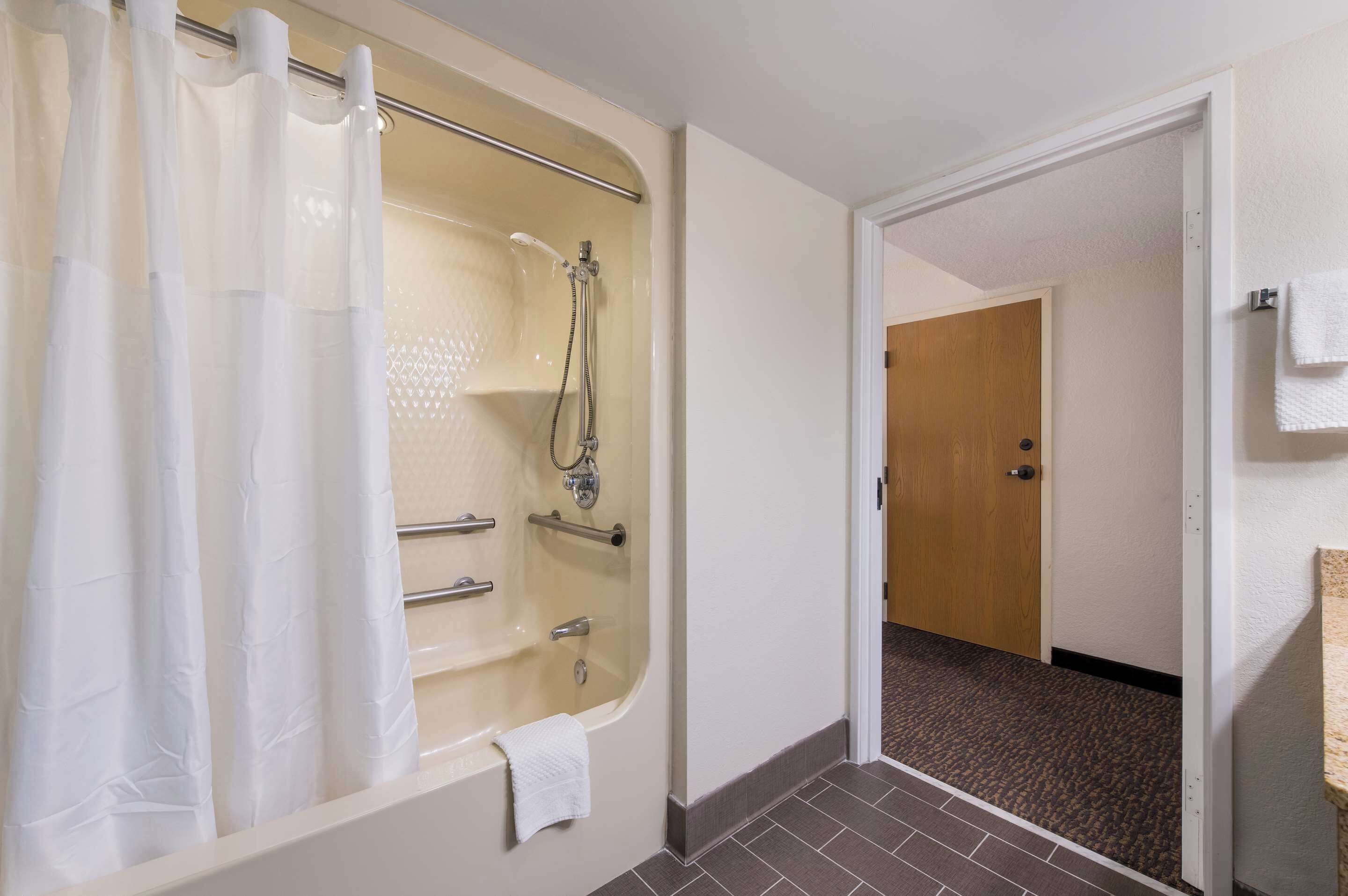 A bathroom with a bathtub, shower, and toilet.