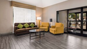 Een moderne woonkamer met een bruine bank, gele fauteuils en een salontafel.