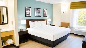 A hotel room with a bed, bedside tables, a chair, a mirror, and framed pictures on the wall. - Sleep Inn Staunton (Staunton)