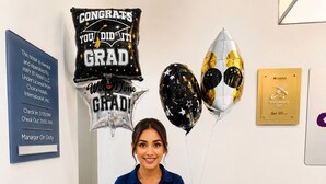 A hotel reception area with a staff member, graduation balloons, a plaque, and gift baskets. - Sleep Inn Staunton (Staunton)