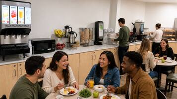 A modern kitchen with a coffee machine, microwave, and a person preparing food.