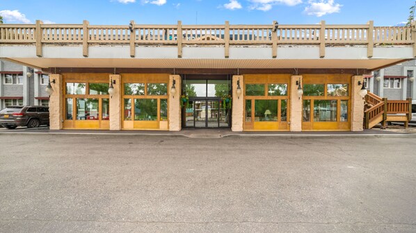 A building with a wooden facade, large glass windows, and a covered entrance.