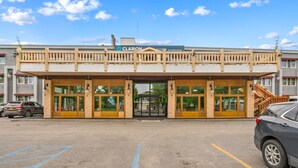 A hotel with a balcony, large windows, and a sign reading "Clarion Suites by Choice Hotels".