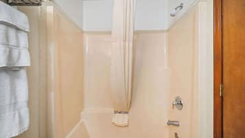 Une salle de bain avec un rideau de douche, un porte-serviettes et une porte dotée d’une poignée.