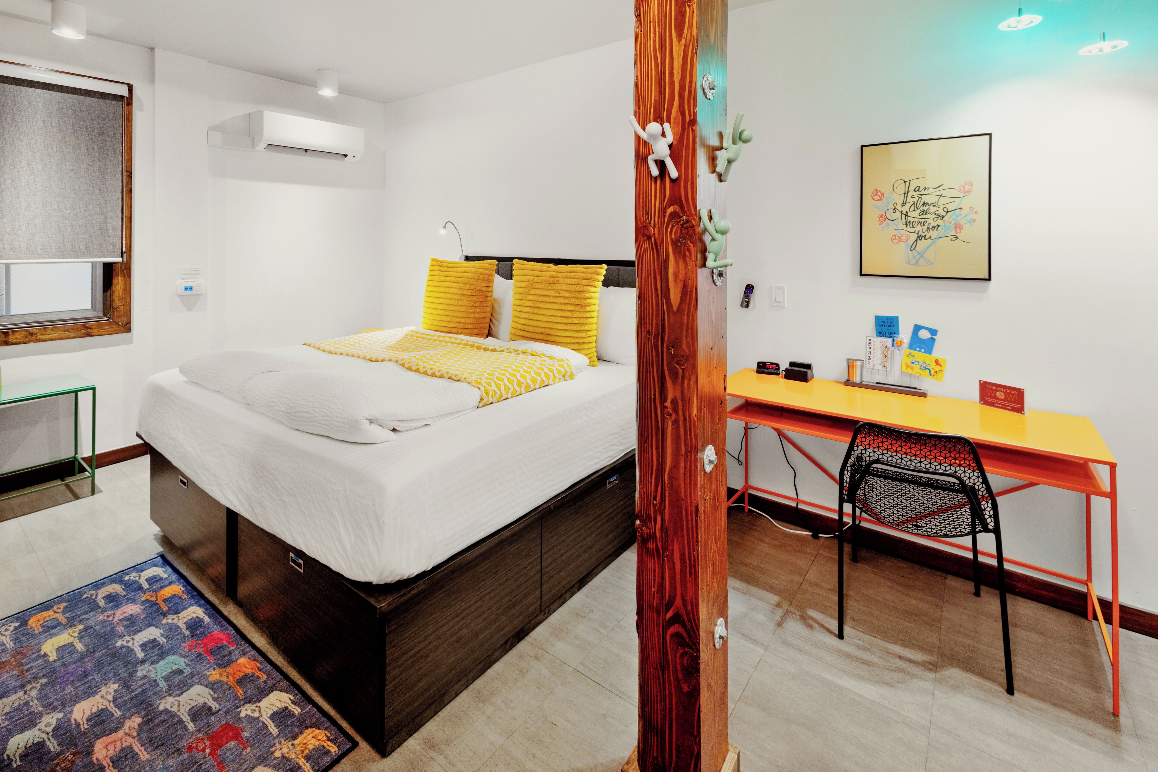 A modern hotel room with a bed, a desk, and a chair.