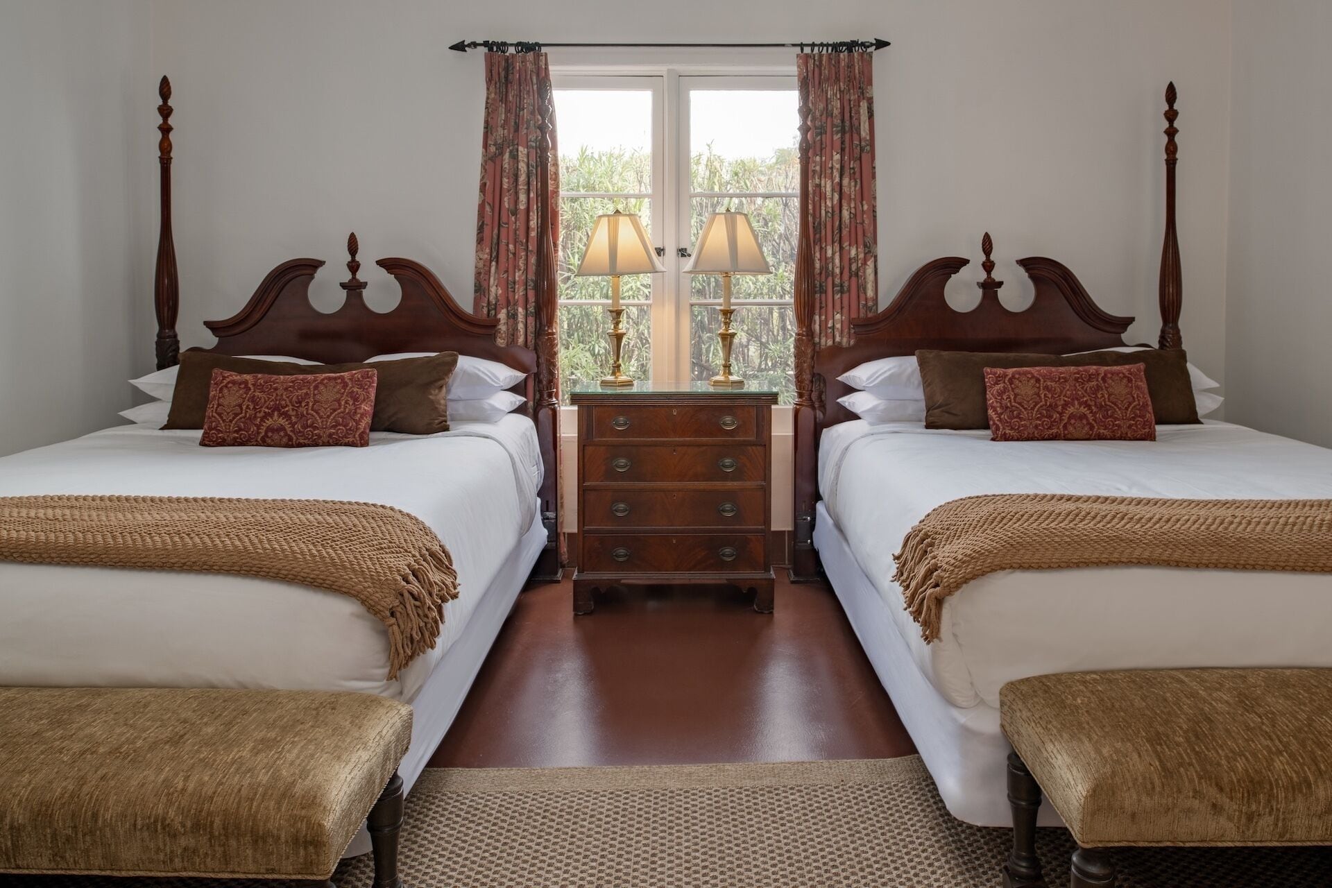 Une chambre avec un lit double doté d’une tête de lit en bois, d’une table de chevet et d’une fenêtre avec des rideaux.