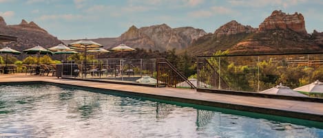 Una piscina al aire libre, sillones reclinables de piscina