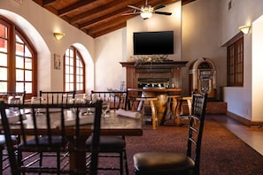 A dining area with a wooden table and chairs, a fireplace, and a television mounted on the wall. - Hilton Vacation Club Los Abrigados Resort & Spa Sedona (Sedona)