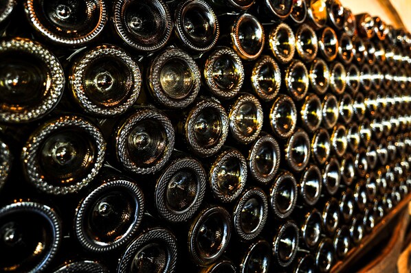 A close-up of numerous cylindrical objects with reflective surfaces, arranged in a repetitive pattern.