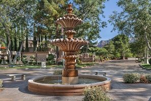 A fountain with multiple tiers and water spouting from the top tier, surrounded by a paved area with benches and trees. - Hilton Vacation Club Los Abrigados Resort & Spa Sedona (Sedona)