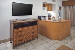 A compact kitchen with a flat-screen TV, wooden cabinetry, a microwave, and a coffee maker. - Hilton Vacation Club Los Abrigados Resort & Spa Sedona (Sedona)