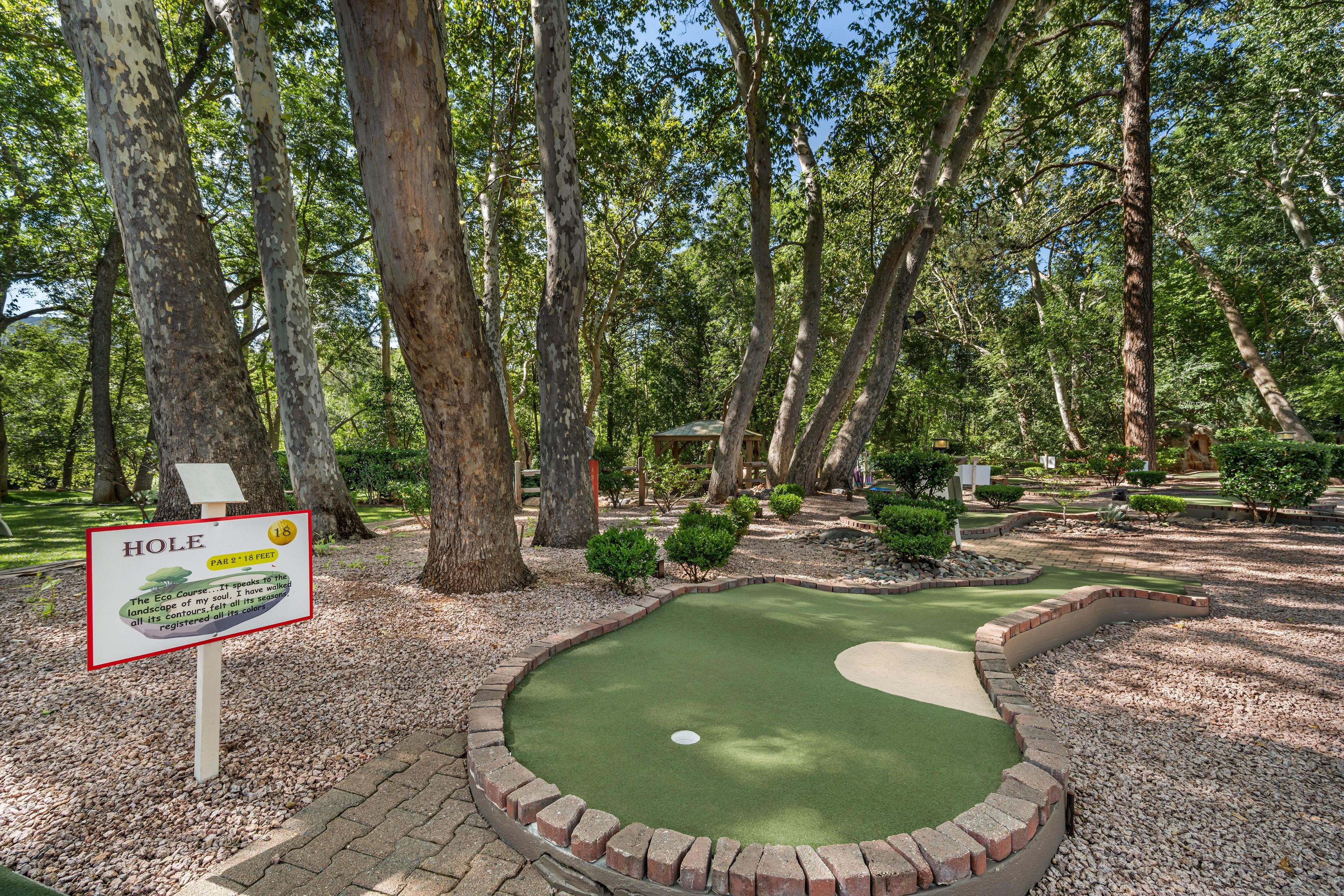A miniature golf course with a sign indicating a hole size of 18 inches.