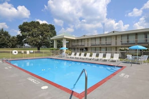 Una piscina al aire libre de temporada, sombrillas