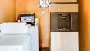 A laundry area with a washing machine, dryer, and a water dispenser.