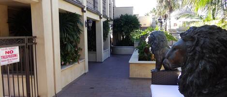 A private property with a 'NO TRESPASSING' sign, a gated entrance, and a lion statue.