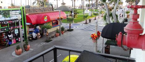 A street view with a taco stand, a green storefront, and a red fire hydrant.