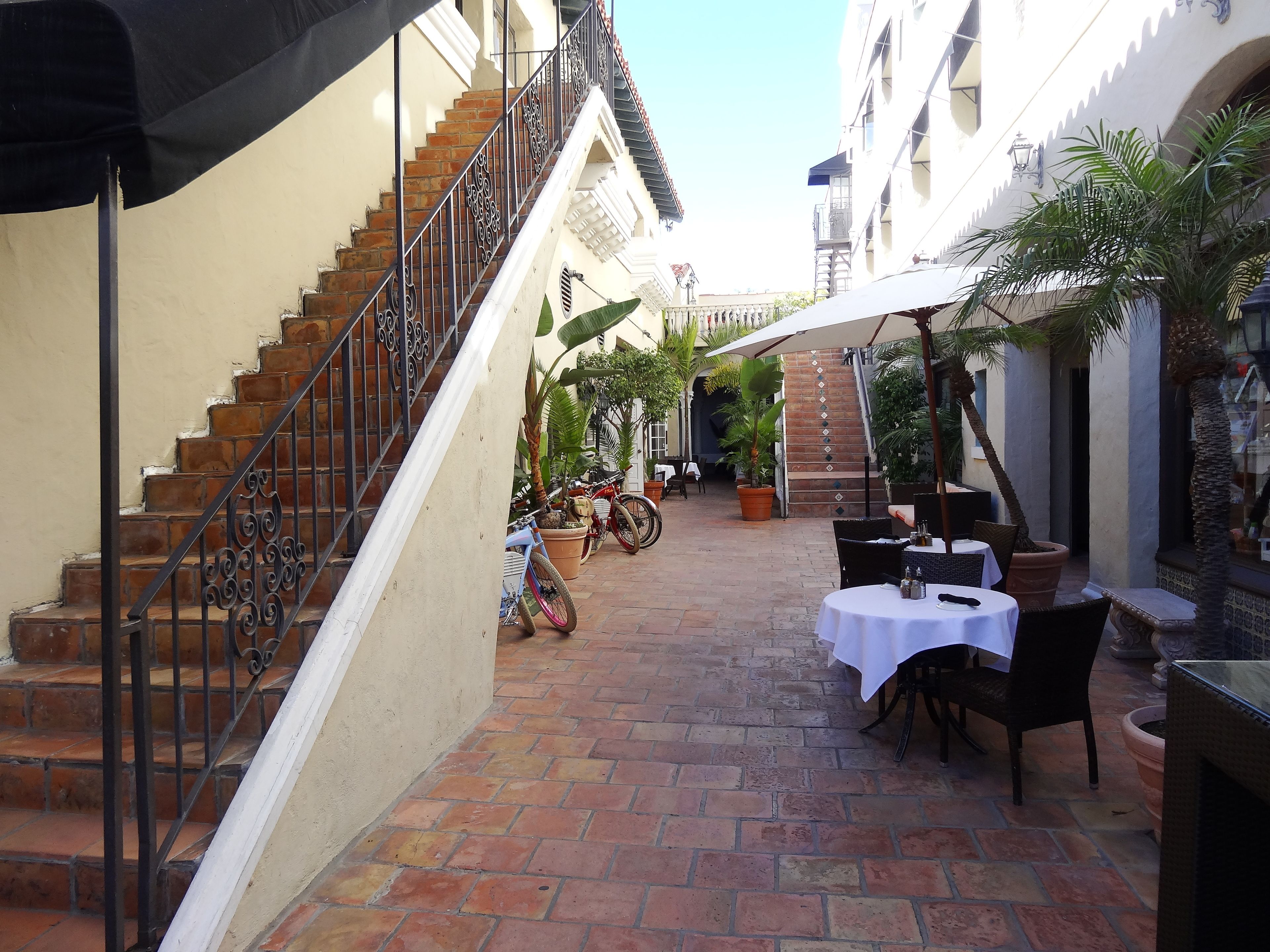 Ein Innenhof mit Treppe, Sitzgelegenheiten und Blumentöpfen.