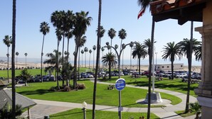 A parking lot with cars, palm trees, and a sign for Balboa Village. - Balboa Inn, On the Beach (Newport Beach)