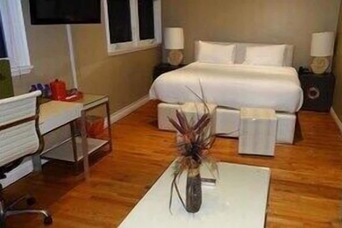 A hotel room with a bed, bedside tables, a desk, and a chair.