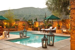 Una piscina al aire libre, camas de piscina gratis, sombrillas