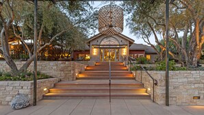 Una escalera de piedra que conduce a un edificio con un gran aplique decorativo sobre la entrada.