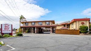 A Red Roof Inn & Suites with a two-story building, a covered parking area, and a clear sky. - Red Roof Inn & Suites Monterey (Monterey)