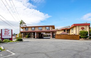 A Red Roof Inn & Suites with a two-story building, a covered parking area, and a clear sky. - Red Roof Inn & Suites Monterey (Monterey)