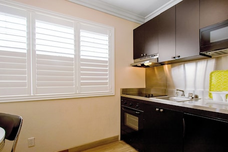 A kitchen with a window, a stove, and a microwave.