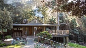 A house with a porch, a deck, and a garden.