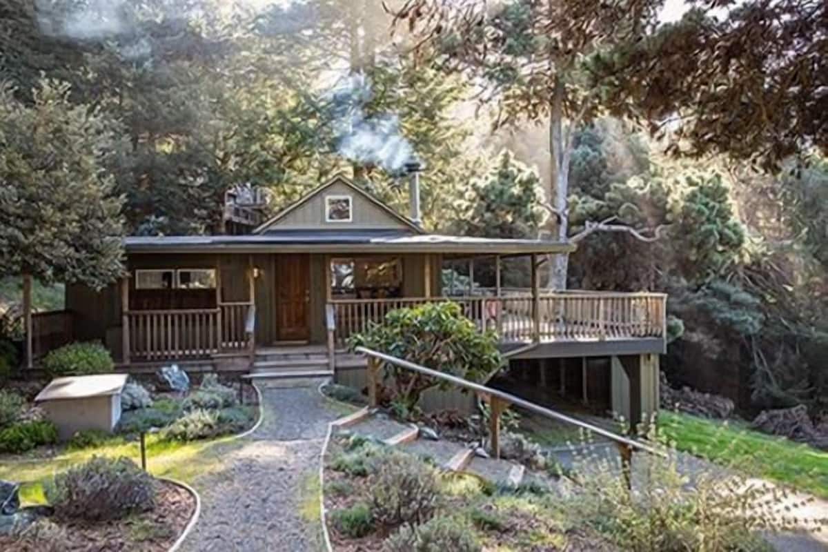 A house with a porch, a deck, and a garden.
