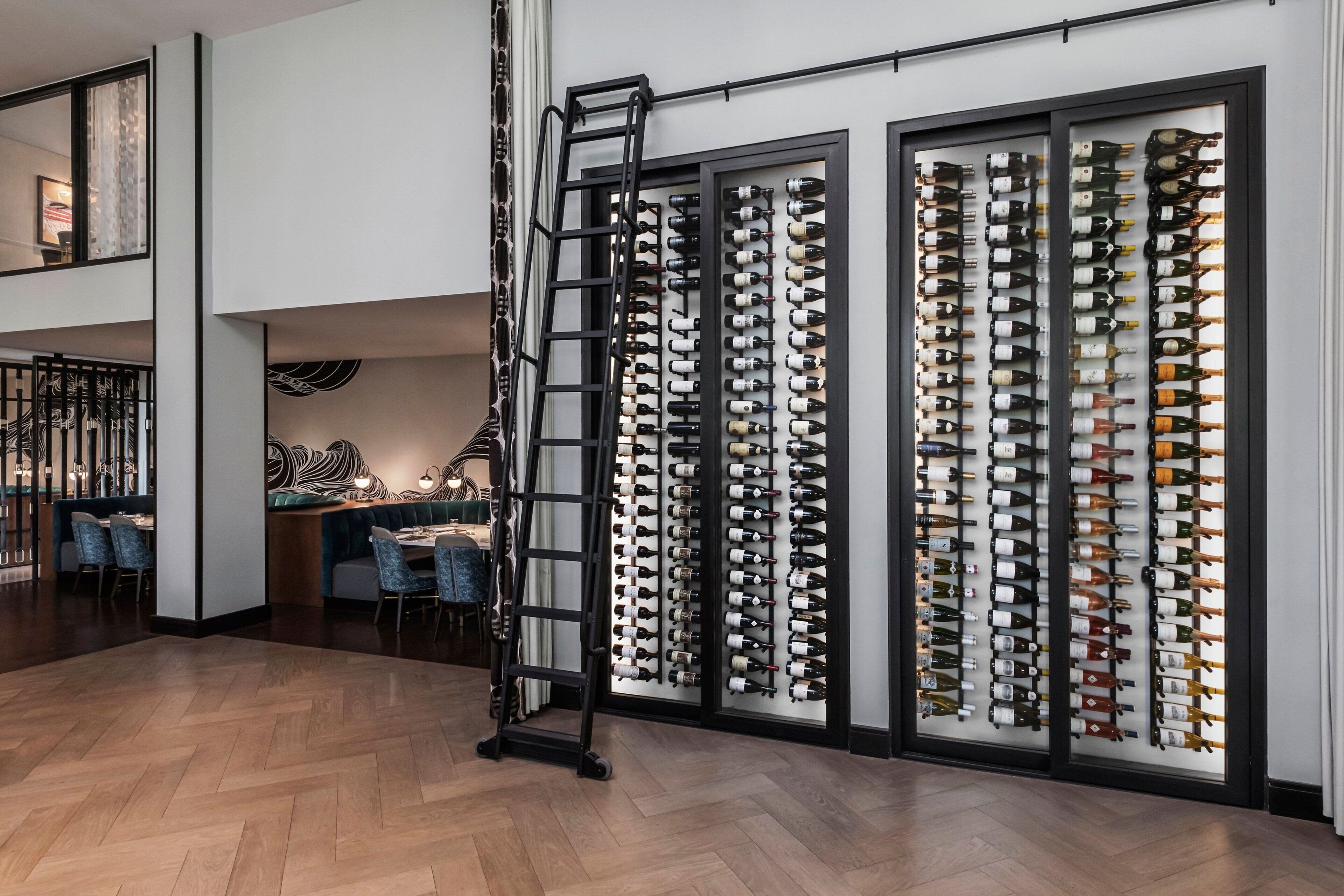 Een modern interieur met een wijnrek, een eethoek en een trap.